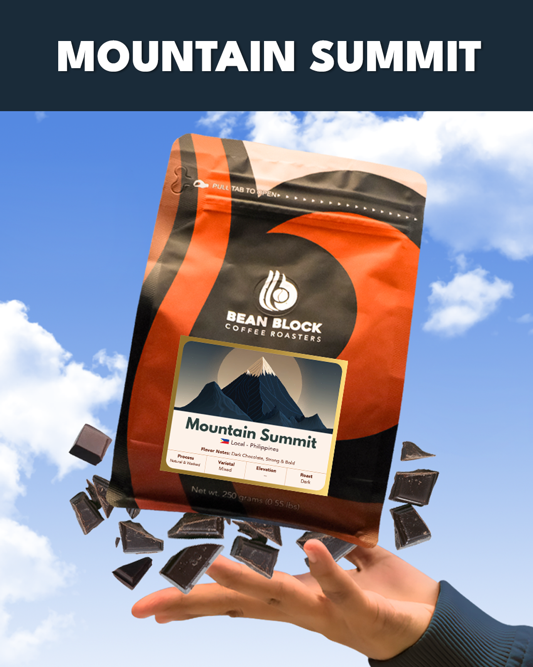 Bean Block Coffee Roasters Mountain Summit 250g coffee package with a hand holding it against a blue sky background.